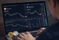 Seorang investor memantau pergerakan harga Bitcoin dan Ethereum di laptop, menampilkan volatilitas pasar crypto pada 27 Januari 2026.