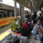 Penumpang menunggu kedatangan kereta api di peron stasiun selama libur Isra’ Mi’raj.
(Foto: AP Photo)