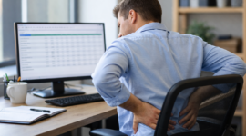 Ilustrasi pekerja kantoran mengalami nyeri punggung akibat kebiasaan duduk terlalu lama.