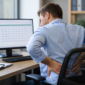 Ilustrasi pekerja kantoran mengalami nyeri punggung akibat kebiasaan duduk terlalu lama.