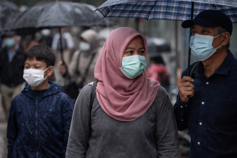 Warga menggunakan masker saat musim hujan sebagai langkah pencegahan infeksi saluran pernapasan akut.