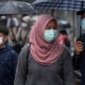 Warga menggunakan masker saat musim hujan sebagai langkah pencegahan infeksi saluran pernapasan akut.