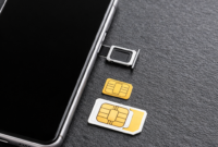 Ilustrasi kartu SIM dan smartphone yang menggambarkan kebijakan baru registrasi kartu seluler berbasis NIK dan biometrik.