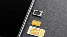 Ilustrasi kartu SIM dan smartphone yang menggambarkan kebijakan baru registrasi kartu seluler berbasis NIK dan biometrik.