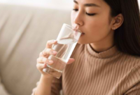 Ilustrasi seseorang minum air putih untuk menjaga hidrasi tubuh dan kesehatan sepanjang hari.