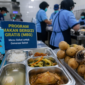Petugas dapur program MBG di Kerinci menyiapkan makanan untuk dibagikan, di tengah sorotan dugaan penyajian susu berperisa dan buah yang tidak layak konsumsi.
