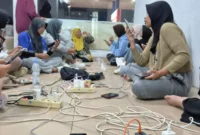 Sejumlah warga mengisi daya gawai di lokasi yang tidak terdampak pemadaman listrik di Kota Padang Jumat (22/5) malam.(Poto : ANTARA ).