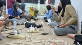 Sejumlah warga mengisi daya gawai di lokasi yang tidak terdampak pemadaman listrik di Kota Padang Jumat (22/5) malam.(Poto : ANTARA ).