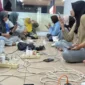 Sejumlah warga mengisi daya gawai di lokasi yang tidak terdampak pemadaman listrik di Kota Padang Jumat (22/5) malam.(Poto : ANTARA ).