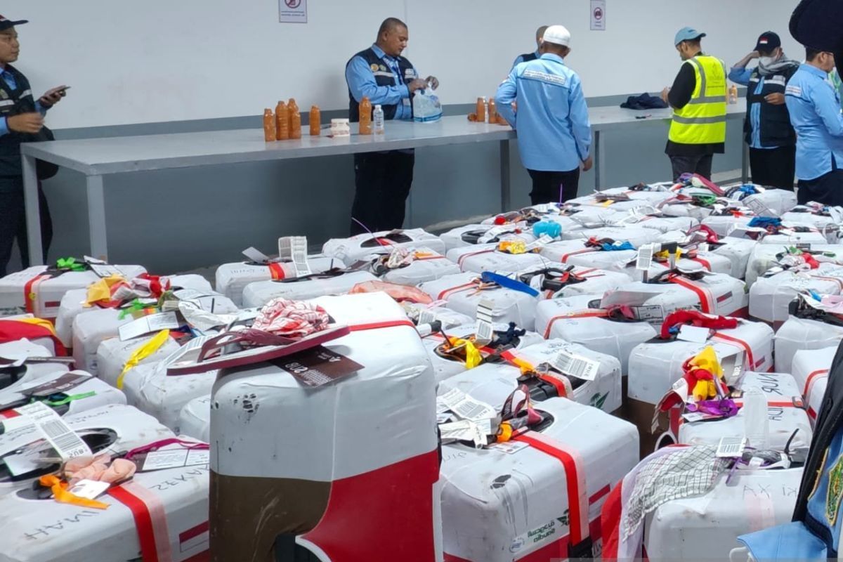 Petugas membongkar koper jamaah yang kedapatan menyimpan air zamzam saat akan pulang ke Tanah Air, Senin (16/6/2025).( poto : ANTARA )