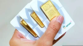 Ilustrasi seorang warga memnunjukan harga emas Antam naik( poto : ANTARA )