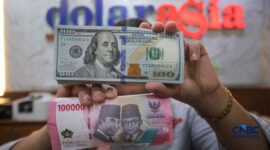 Foto: Petugas menjunjukkan uang pecahan dolar Amerika Serikat (AS) dan rupiah di Dolar Asia Money Changer, Jakarta, Rabu (8/7/2026). (CNBC Indonesia/Faisal Rahman)