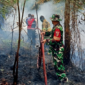 Babinsa Koramil 416-06/MB langsung bergerak cepat setelah menerima laporan kebakaran lahan sungai buluh pada Senin (24/8/2026).(poto: oegopost.id).