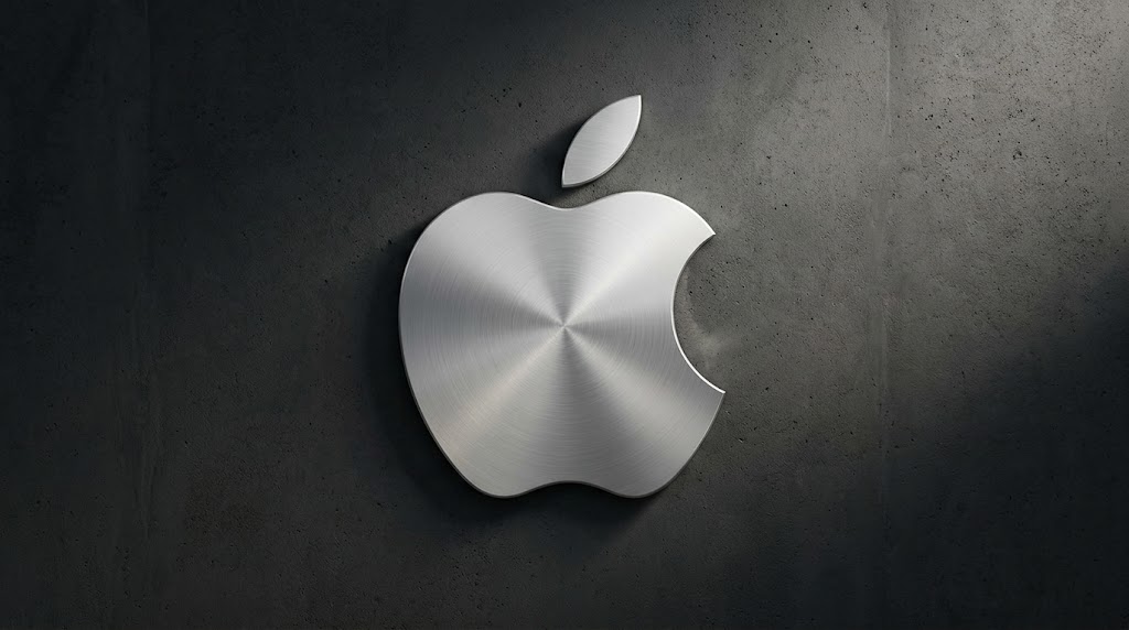 Logo Apple berbahan logam perak dengan tekstur melingkar yang elegan, terpasang pada dinding beton gelap.(poto: AI).