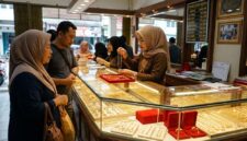Pelayan toko emas di Jambi menunjukkan kalung perhiasan kepada pembeli di depan etalase berkilau penuh perhiasan.(ilustrasi poto: AI).
