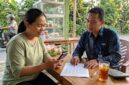 Petugas Mantri BRI menjelaskan tabel simulasi angsuran KUR kepada pelaku usaha mikro di warung kelontong.(ilustrasi poto: AI).