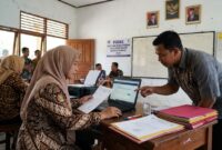 Ilustrasi: Guru memeriksa berkas pendaftaran seleksi PPPK Guru Agama Sekolah Rakyat 2026 melalui portal resmi SSCASN.(poto: AI).