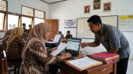 Ilustrasi: Guru memeriksa berkas pendaftaran seleksi PPPK Guru Agama Sekolah Rakyat 2026 melalui portal resmi SSCASN.(poto: AI).