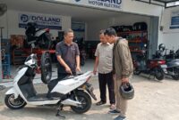Ilustrasi: Mekanik di bengkel Dolland Motor Electric Bekasi tengah menjelaskan komponen dan baterai motor listrik kepada konsumen.(poto: AI).