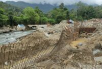 Alat berat dan pekerja memperbaiki tanggul penahan sungai yang rusak akibat banjir di Kota Padang.(poto: metrotvnews.com).