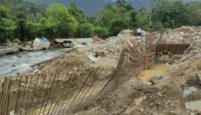Alat berat dan pekerja memperbaiki tanggul penahan sungai yang rusak akibat banjir di Kota Padang.(poto: metrotvnews.com).