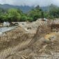 Alat berat dan pekerja memperbaiki tanggul penahan sungai yang rusak akibat banjir di Kota Padang.(poto: metrotvnews.com).